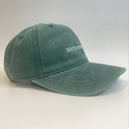 100% Green washed cotton cap with 'uncommon' white embroidery. 