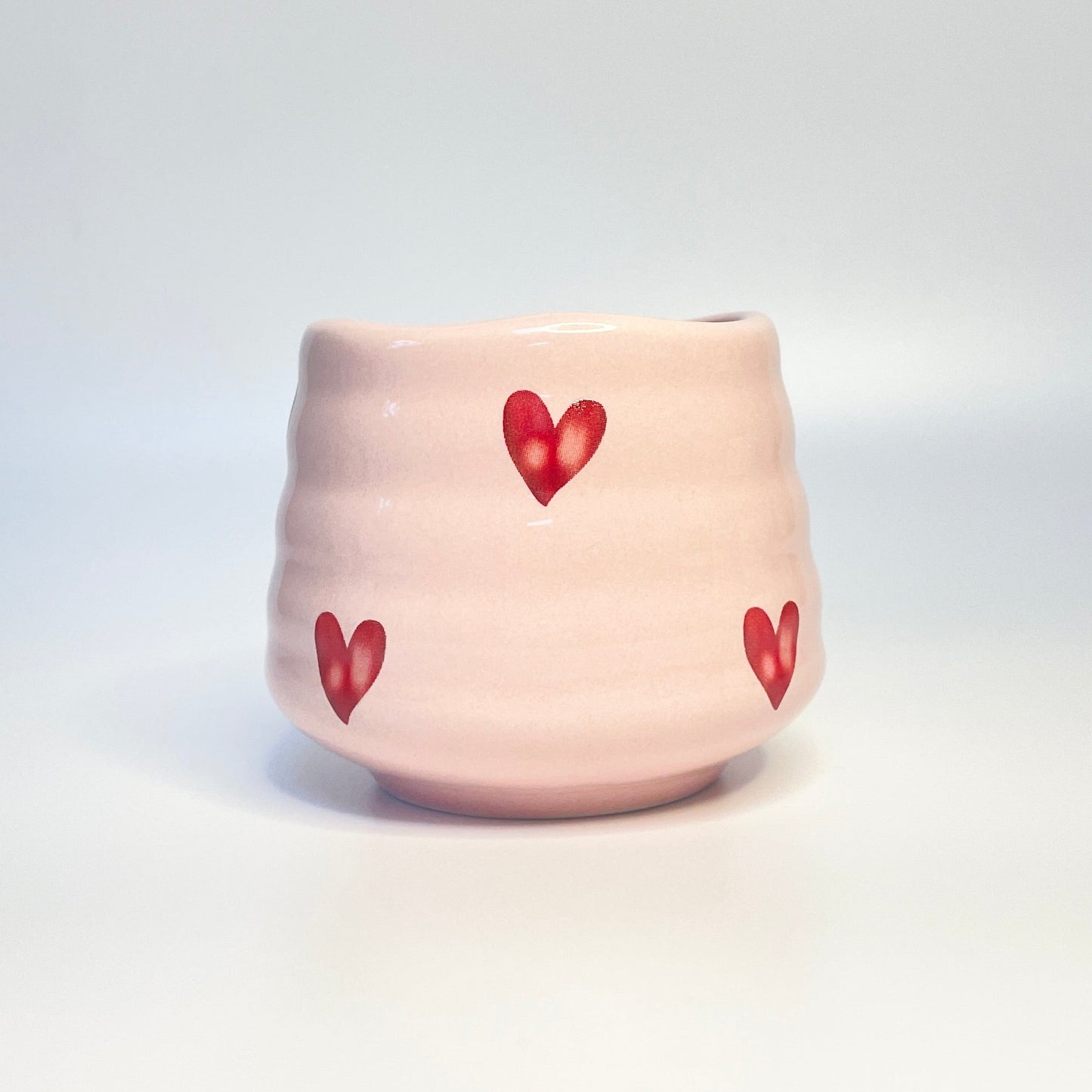 light pink match holder/ coffee cup with red hearts.