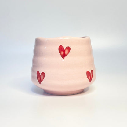 light pink match holder/ coffee cup with red hearts.