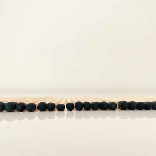 4.8 cm black matches on a white surface. 