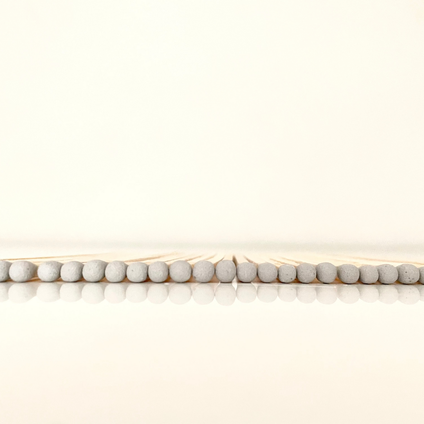 9.8 cm grey matches on white surface.