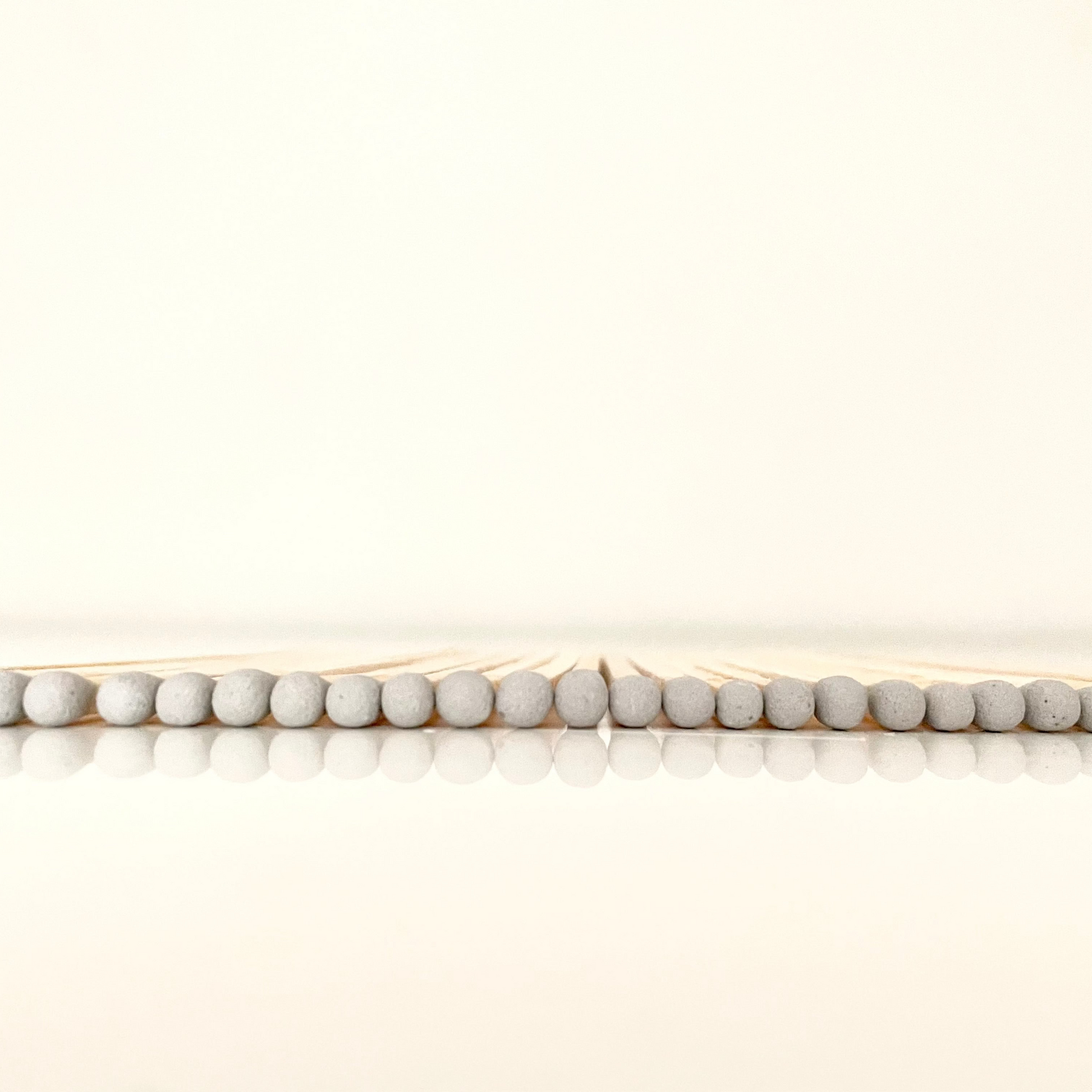9.8 cm grey matches on white surface.