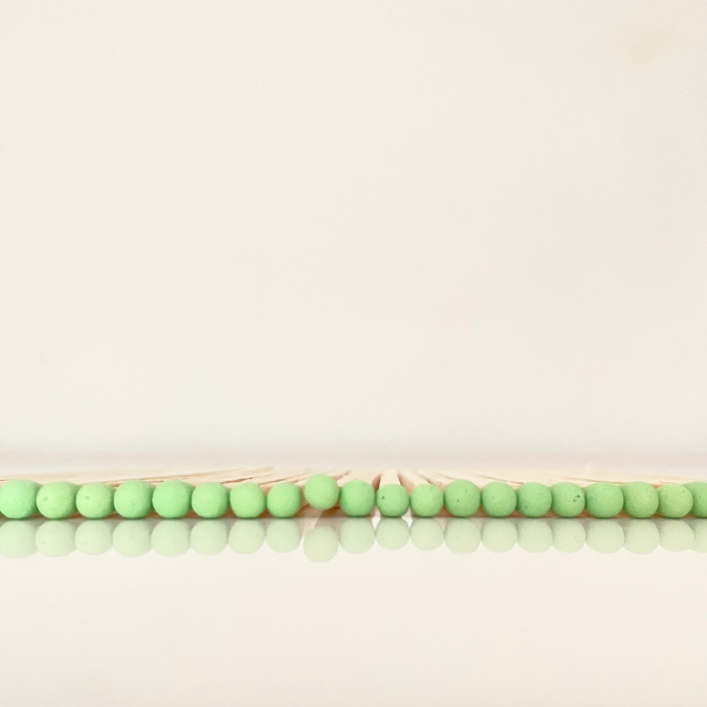 9.8 cm pistachio matches on white surface.