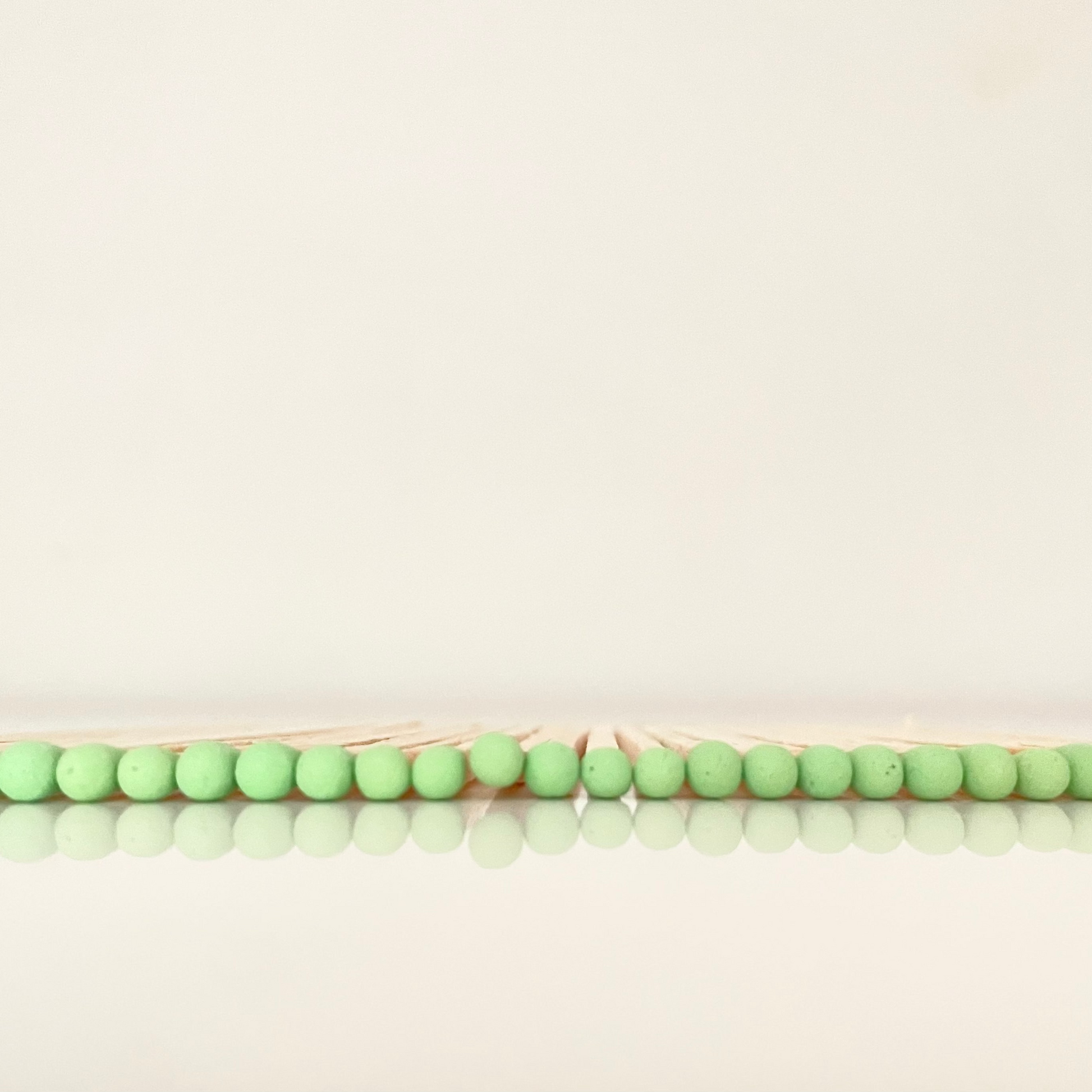 9.8 cm pistachio matches on white surface.