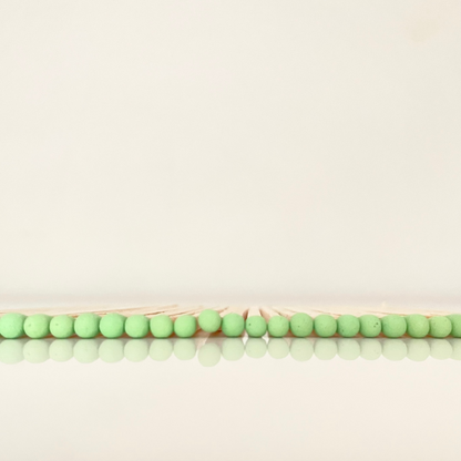 9.8 cm pistachio matches on white surface.