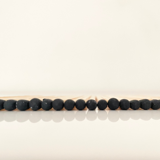 9.8 cm black matches on white surface.