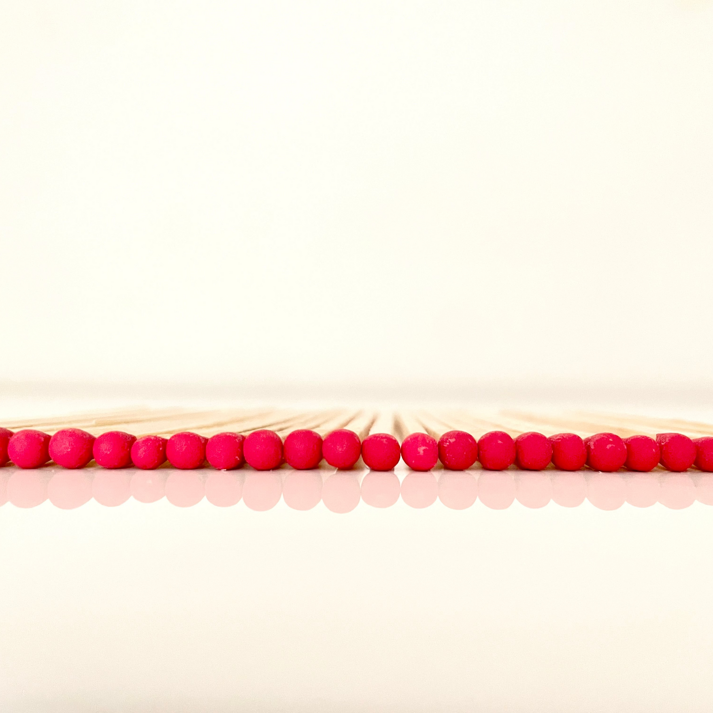 9.8 cm red matches on white surface.