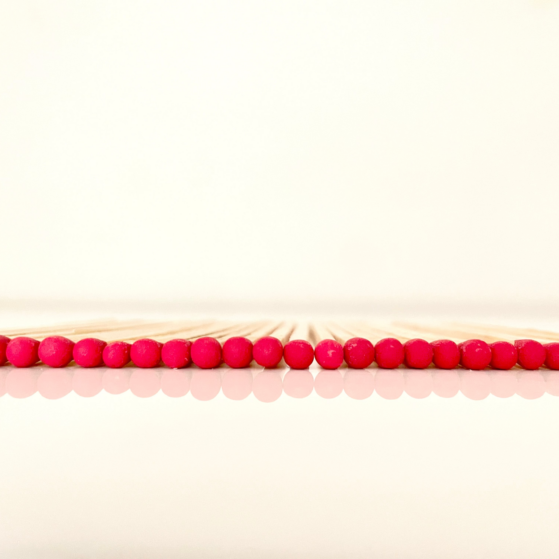 9.8 cm red matches on white surface.