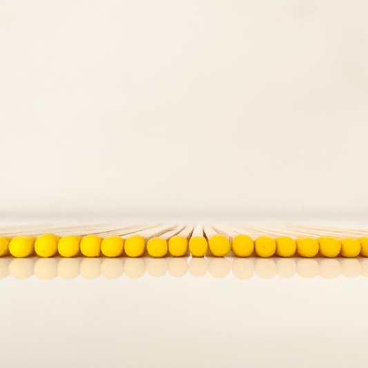 9.8 cm yellow matches on white surface.
