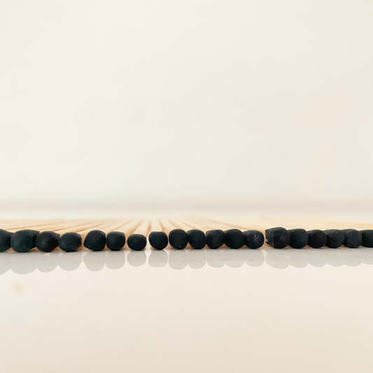 7.5 cm black matches on a white surface. 