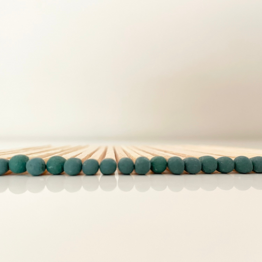9.8 cm dark green matches on white surface.