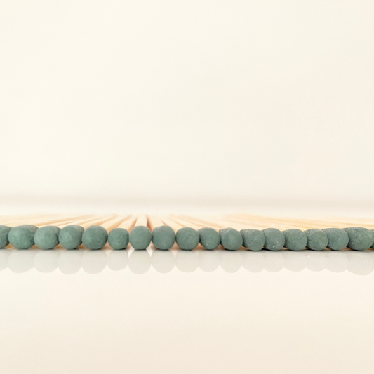 7.5 cm forest green matches on a white surface. 