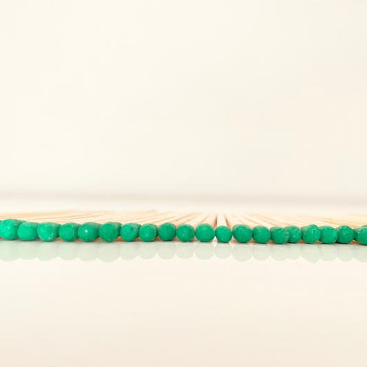 7.5 cm green matches on a white surface. 