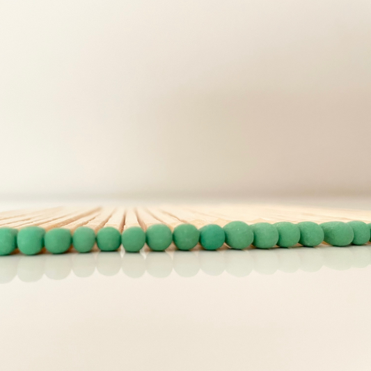9.8 cm green matches on white surface.