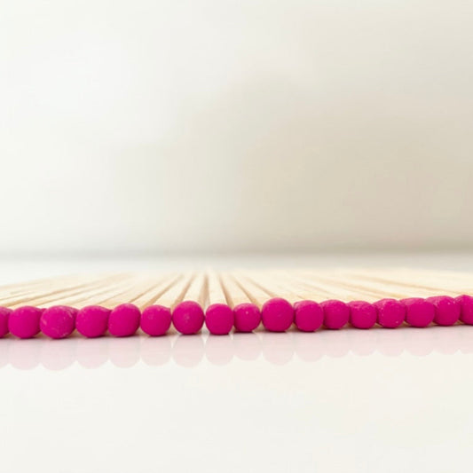 9.8 cm hot pink matches on white surface.