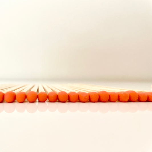 9.8 cm orange matches on white surface.