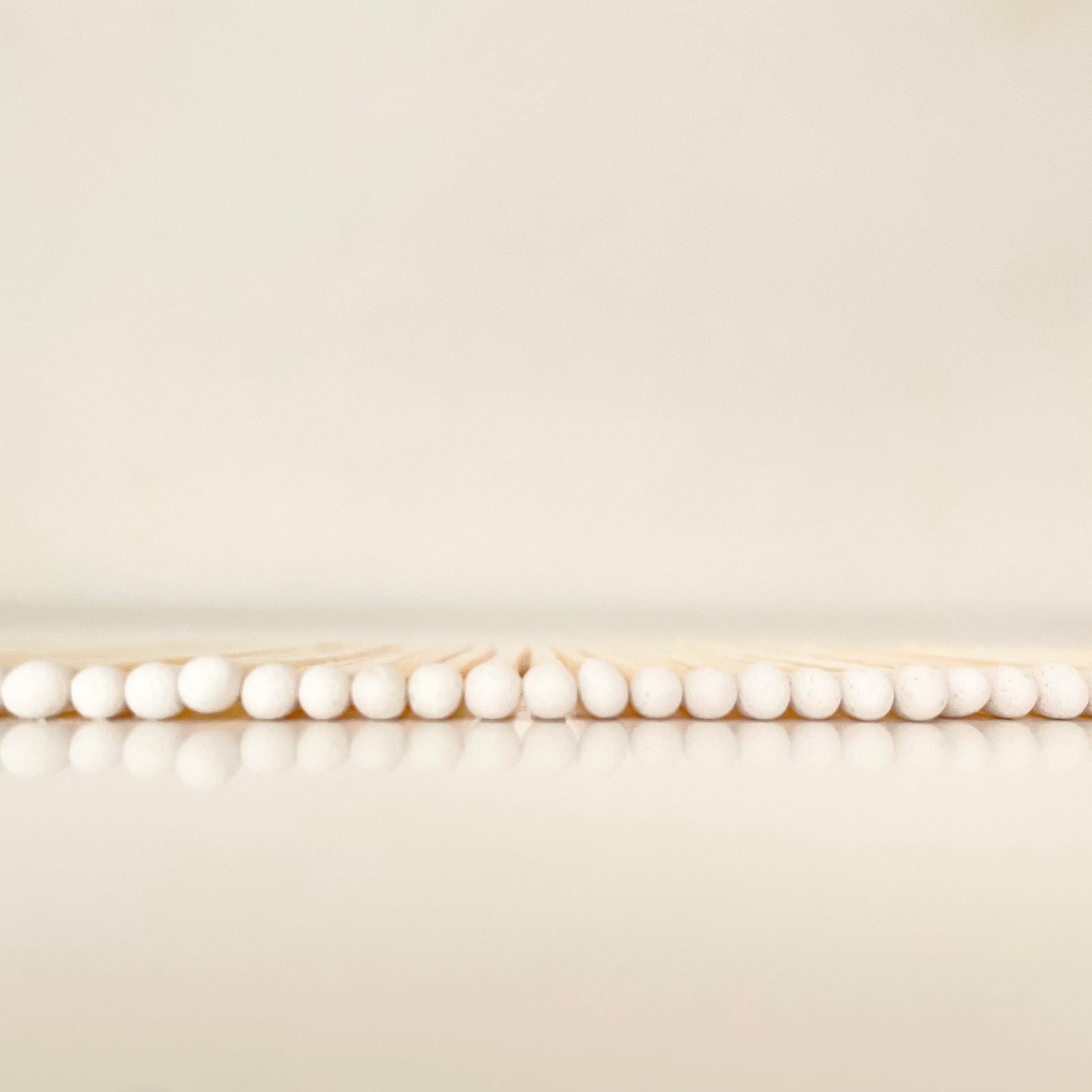 7.5 cm white matches on a white surface. 