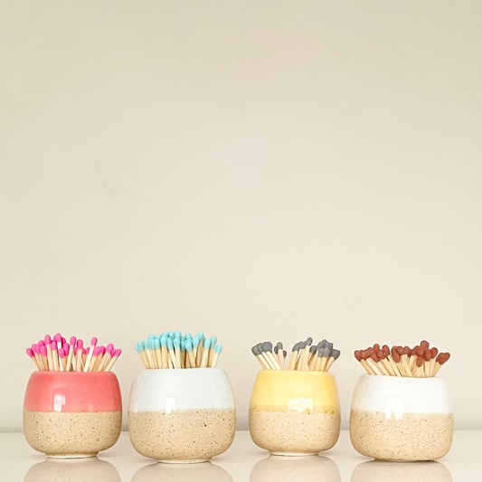 Pastel match holders on a white surface.