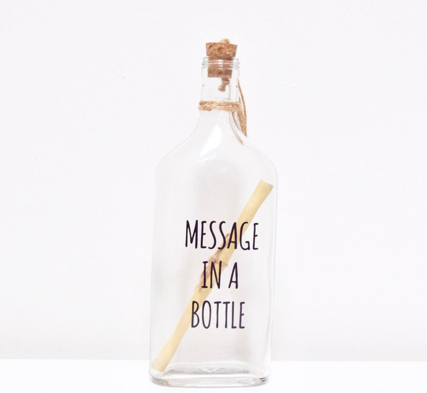 A glass bottle  with a message "MESSAGE IN A BOTTLE" and a cork lid, containing a scroll to write your personalised text.