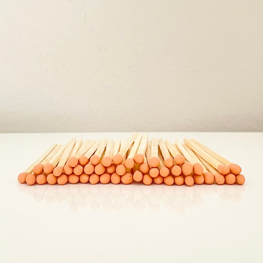 7.5 cm orange matches on a white surface. 