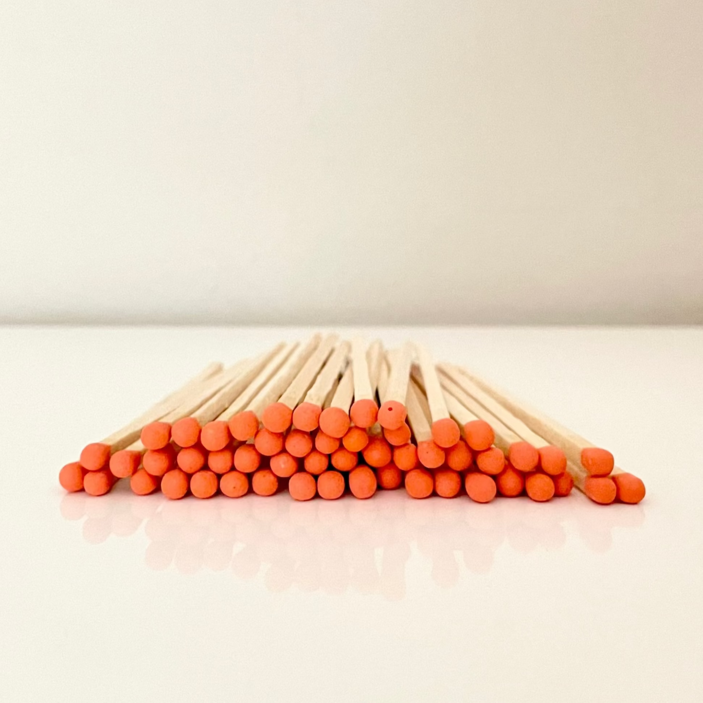 9.8 cm orange matches on a white surface. 