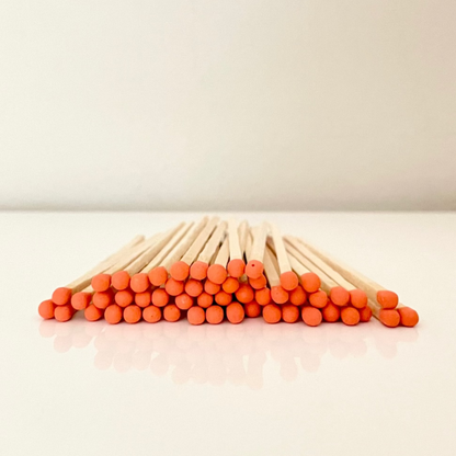 9.8 cm orange matches on a white surface. 