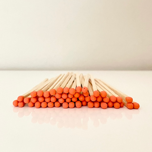 9.8 cm orange matches on a white surface. 