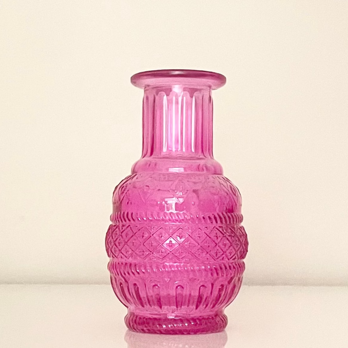 Pink glass vase (E) with textured surface on a white background.