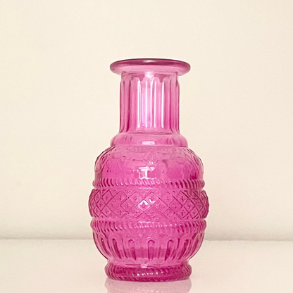 Pink glass vase (E) with textured surface on a white background.