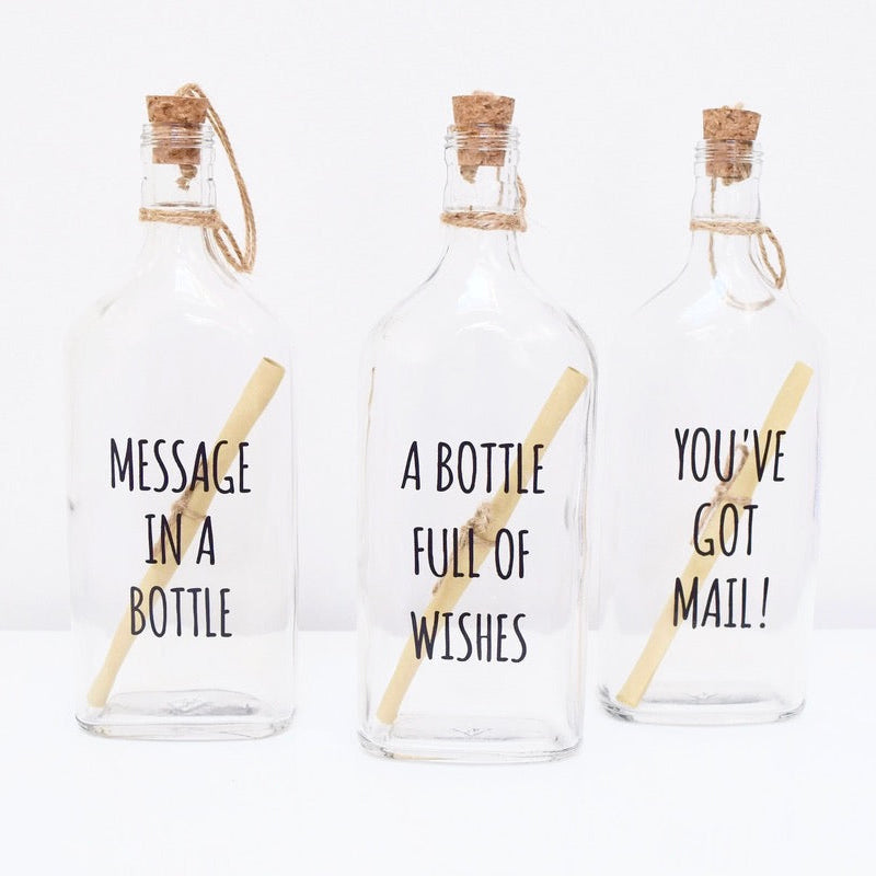 Three glass bottles with cork lids, each containing a scroll to write your personalised text.