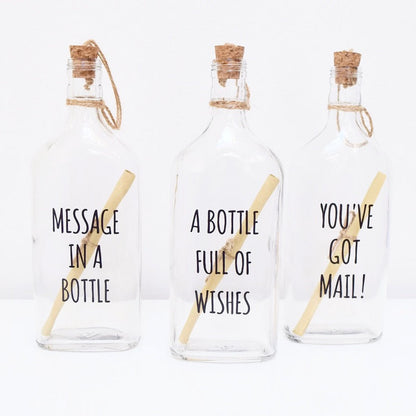Three glass bottles with cork lids, each containing a scroll to write your personalised text.
