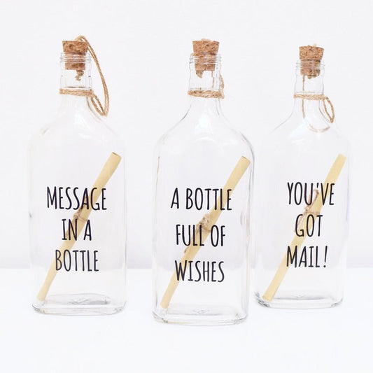 Three glass bottles with cork lids, each containing a scroll to write your personalised text.