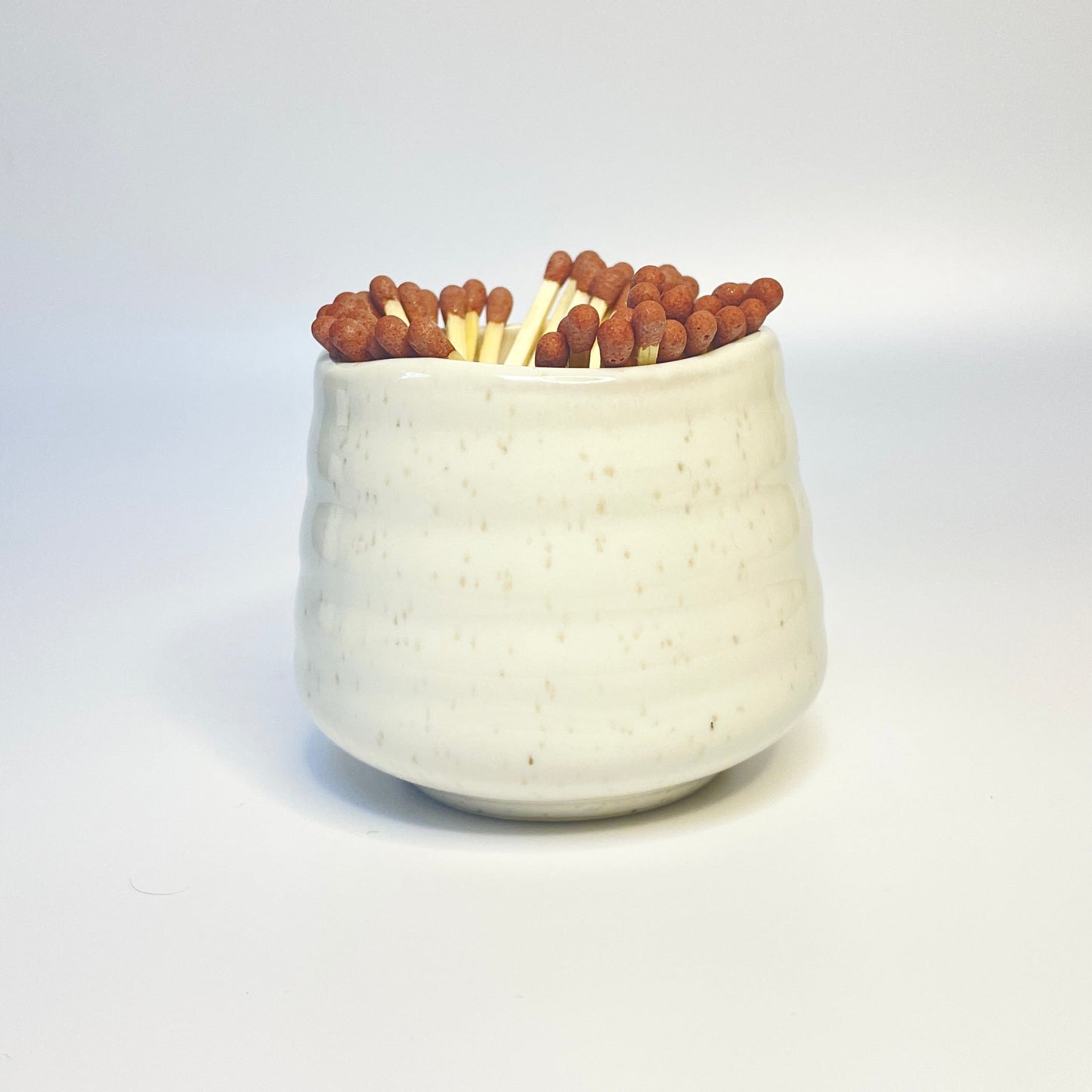 white sprinkled match holder with brown coloured safety matches.
