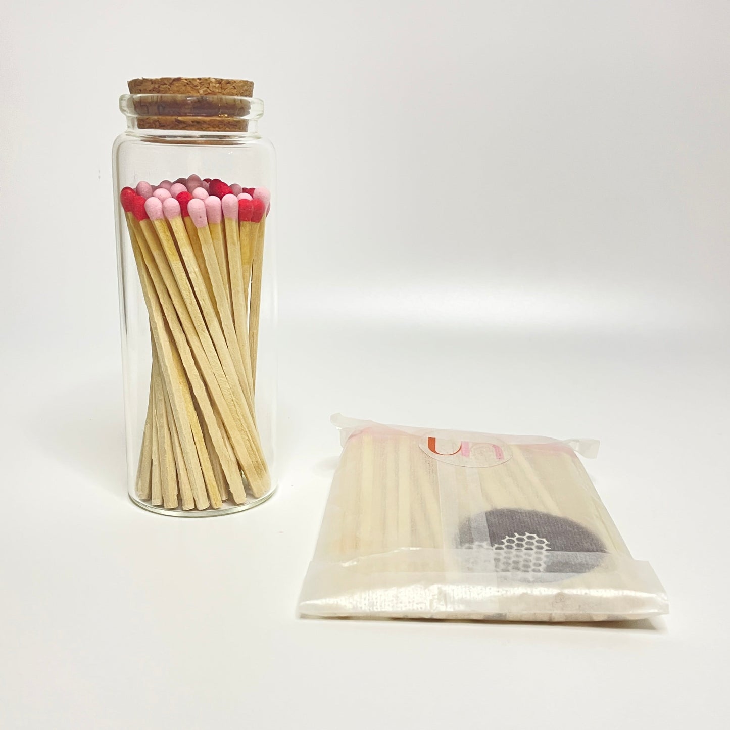 Test tube bottle filled with 9.8 cm matches and refill matches on a white background. 
