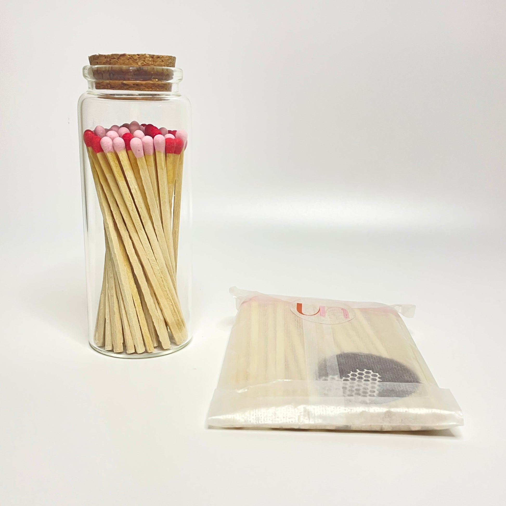 Test tube bottle filled with 9.8 cm matches and refill matches on a white background. 