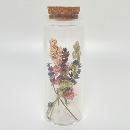 Test tube glass bottle filled with dried delphinium and lavender. 