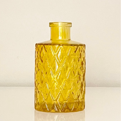 Mustard glass vase (A) with textured surface on a white background.