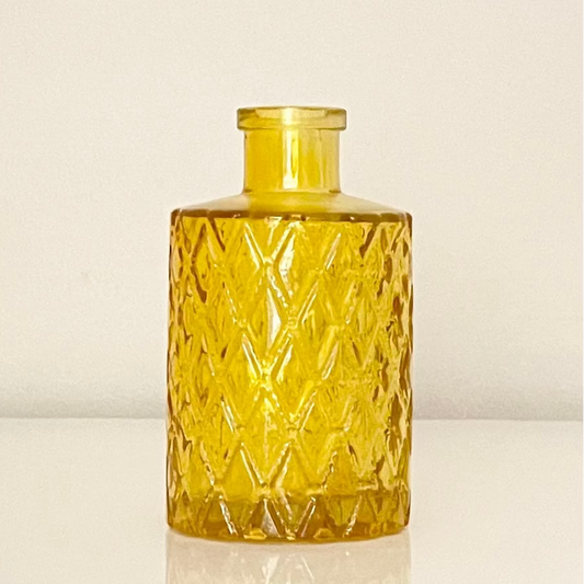 Mustard glass vase (A) with textured surface on a white background.