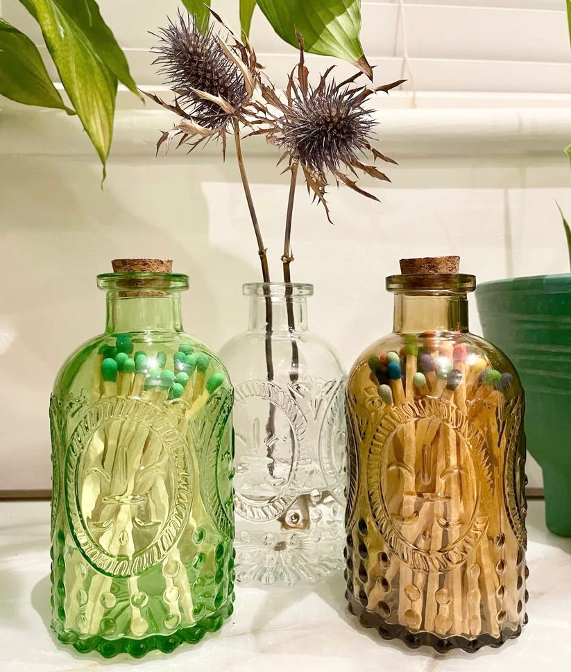 Vintage glass vases with corks, available in green, clear and amber. These multipurpose jars are perfect for holding matches (sold separately), storing small items, or to display fresh or dried flowers. 