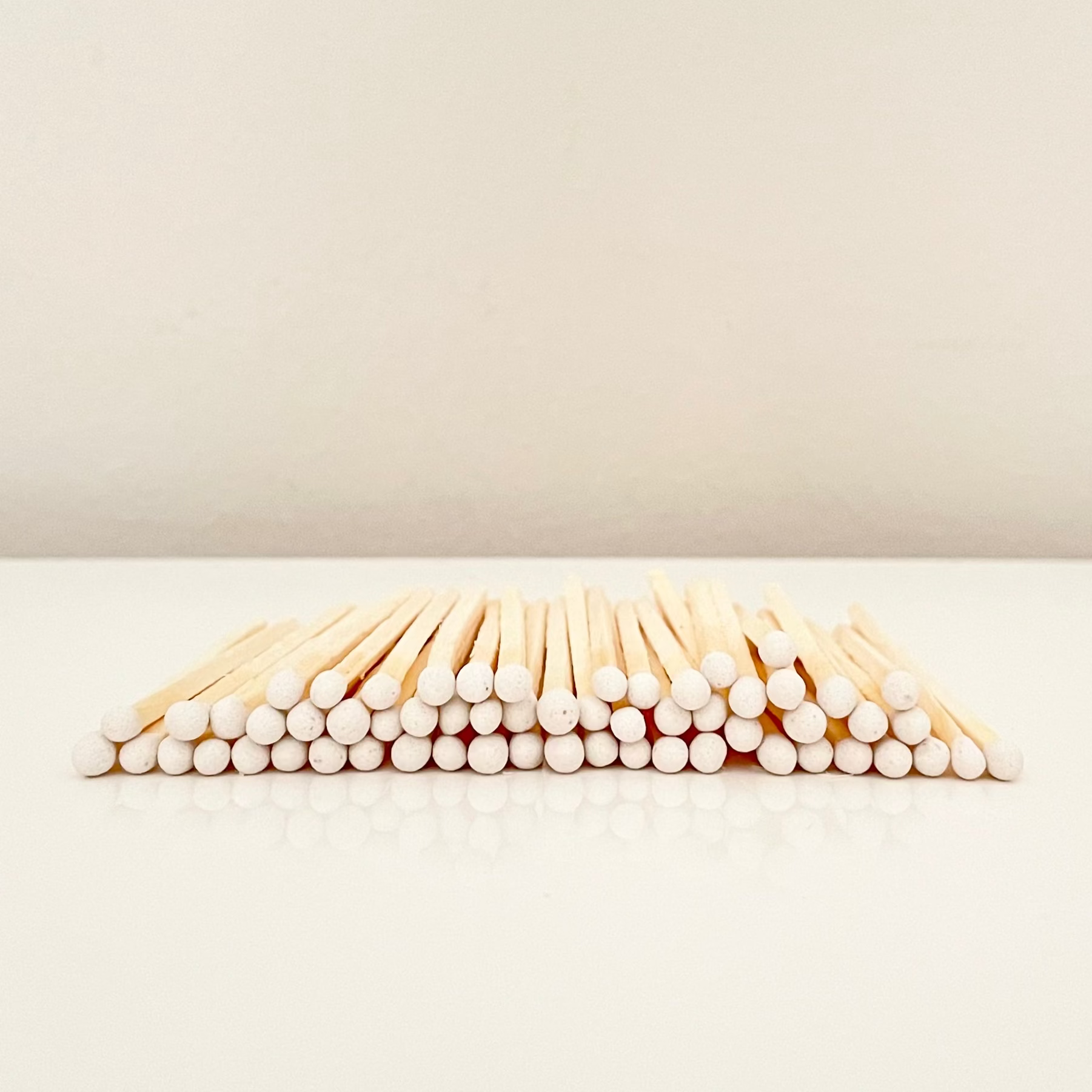7.5 cm white matches on a white surface. 