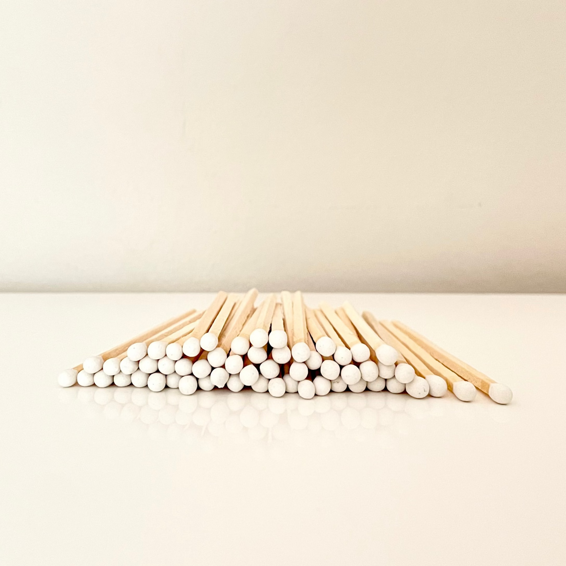 9.8 cm white matches on surface.