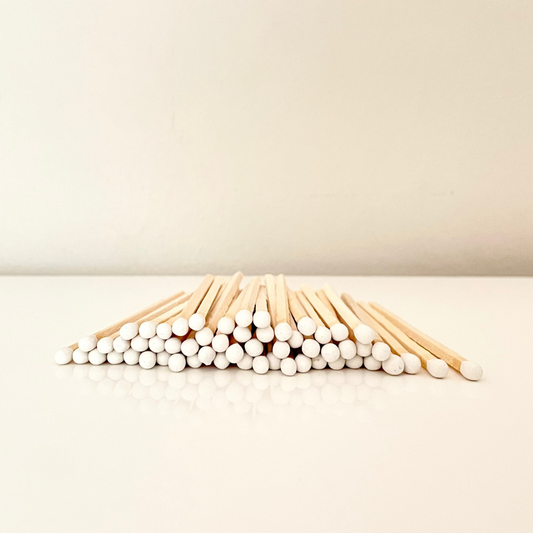 9.8 cm white matches on surface.