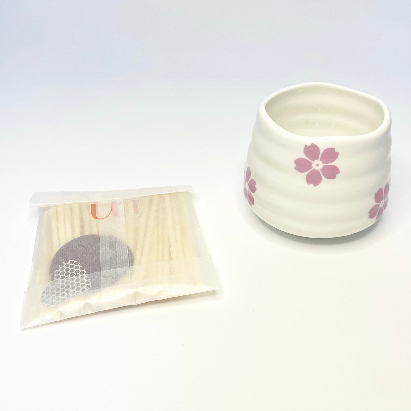 A gift set consisting of a white match holder/coffee cup and 50 purple and light pink 7.5cm matches.
