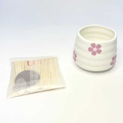 A gift set consisting of a white match holder/coffee cup and 50 purple and light pink 7.5cm matches.