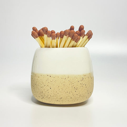 White ceramic match holder on a white surface.