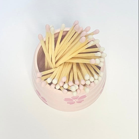 Refill Matches in a pink ceramic mach holder with flowers. 