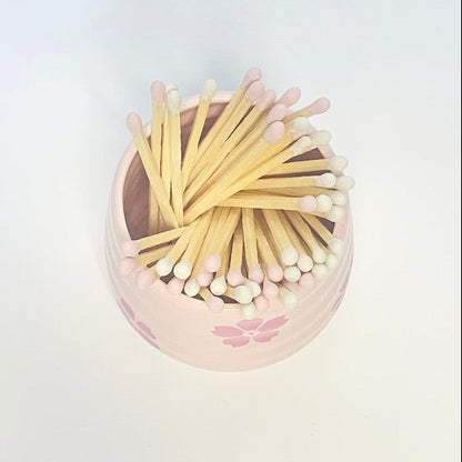 Refill Matches in a pink ceramic mach holder with flowers. 