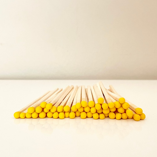 9.8 cm yellow matches on a white surface. 